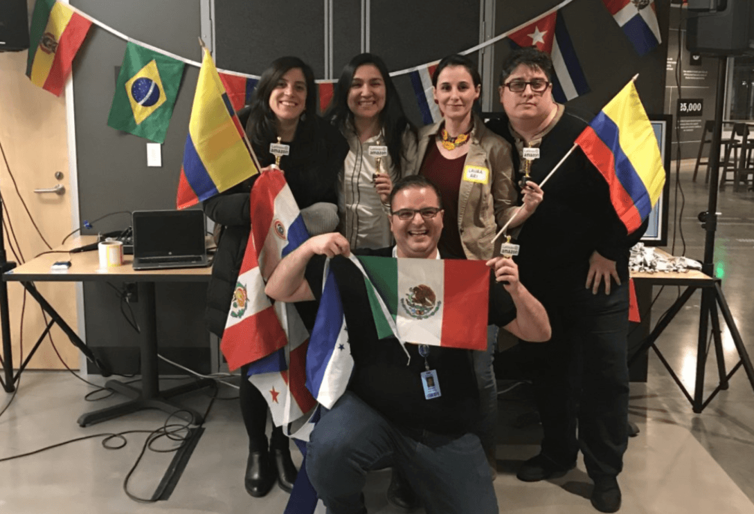 A photo of Amazon employees posing with various flags at the 2019 Hispanic Heritage Month celebration.