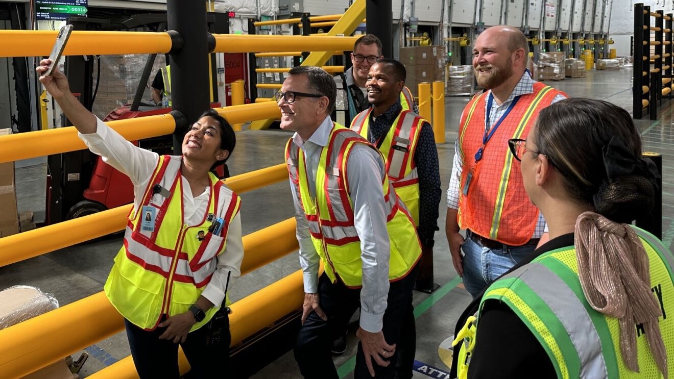 Amazon Stores CEO Doug Herrington poses for a photo with Amazon employees wearing safety vests