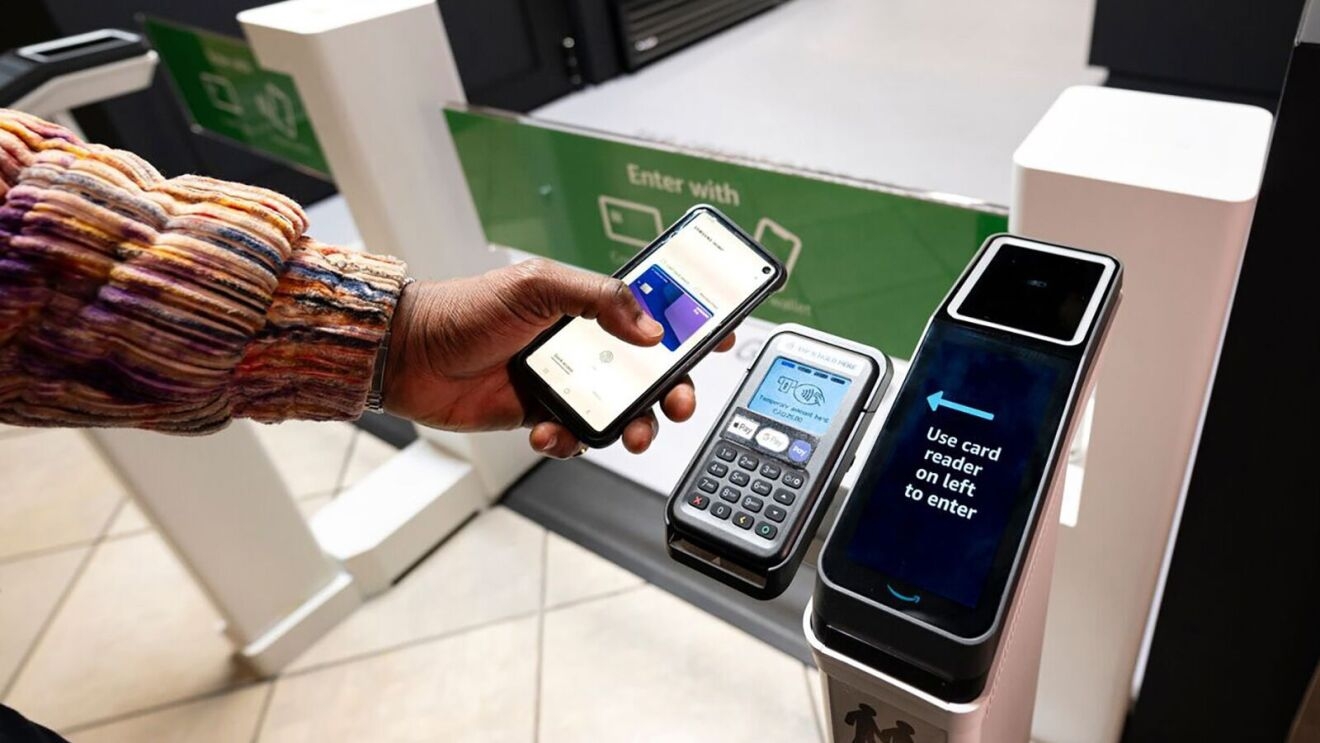 Contactless card Just Walk Out payment terminal with hand holding phone