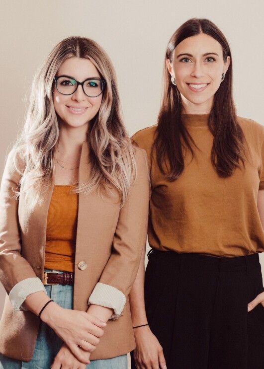 Two women smile at the camera, in a headshot