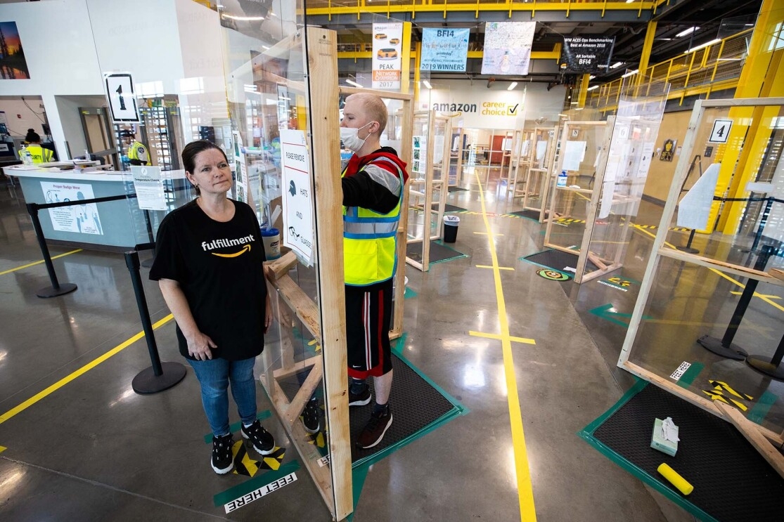 Amazon associate in a fulfillment center following additional safety proceedures in response to the COVID-19 pandemic