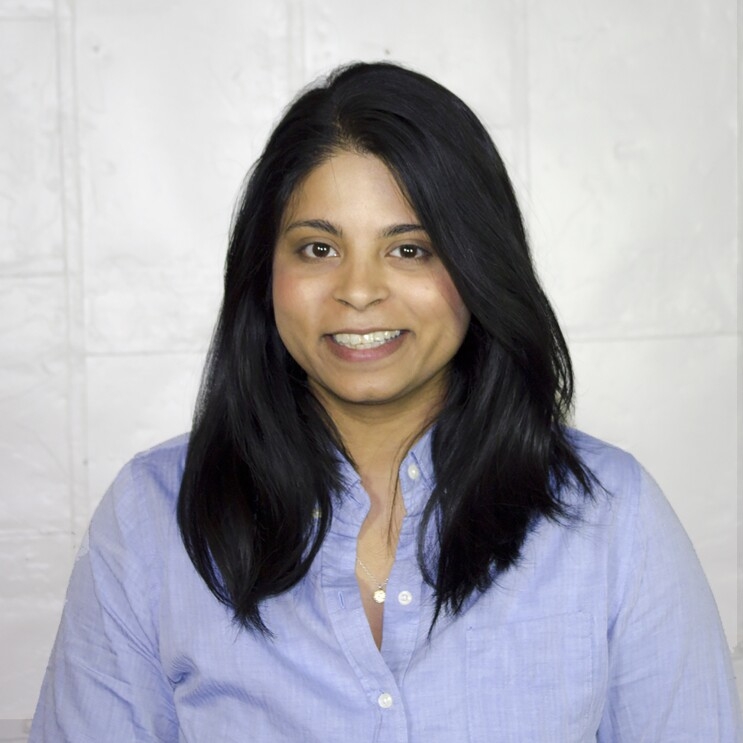 Woman smiles at the camera, in a headshot