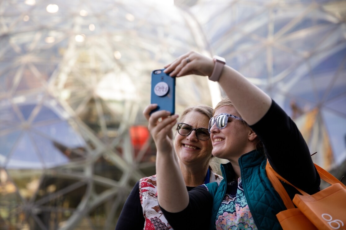A mother and daughter take a candid selfie in front of The Spheres in downtown Seattle