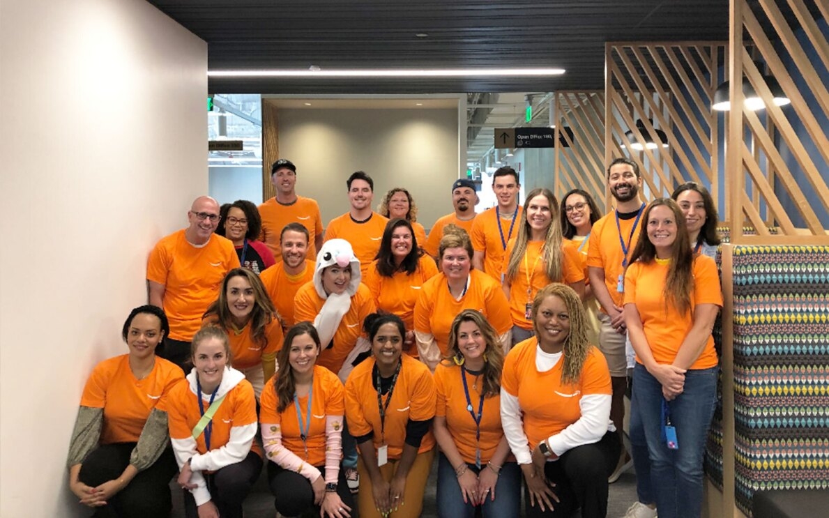 A group of Amazon volunteers wear orange T-shirts.