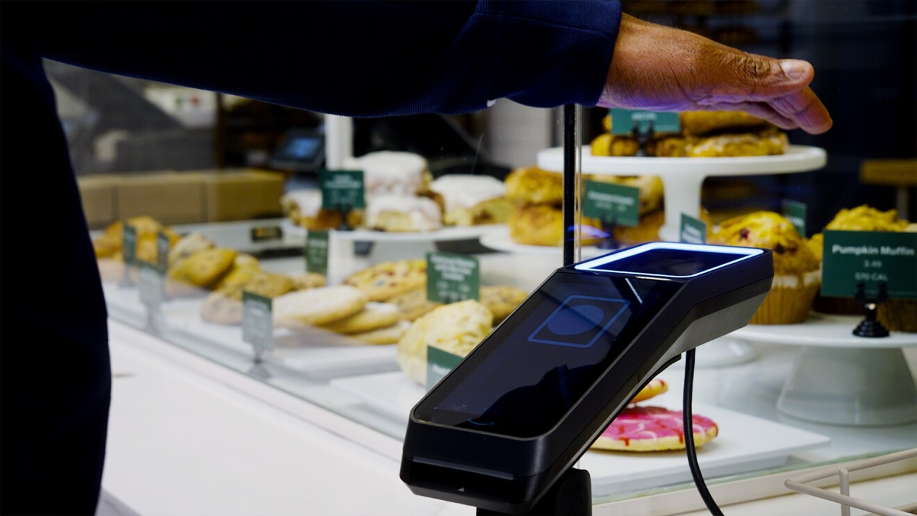 A man pays using Amazon One at a Panera store.