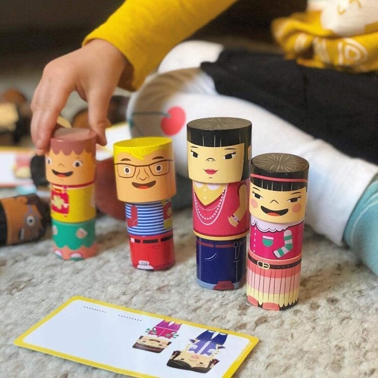 A child plays with four stacks of family builder toys.