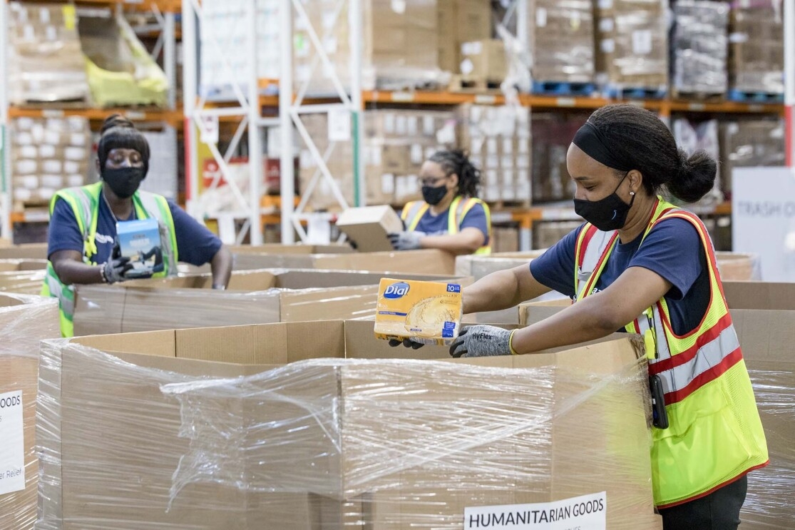 Person working with an Amazon Disaster Relief Hub prepares supplies for humanitarian and disaster relief efforts. 