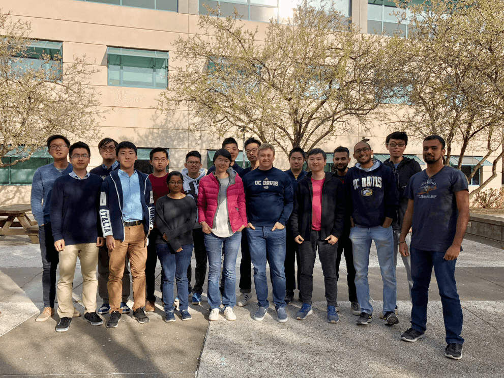 A group of students and their advisor stand outside a campus building at UC Davis