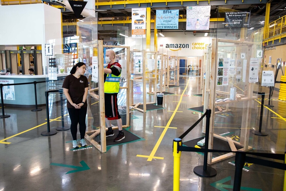 Amazon associate in a fulfillment center following additional safety proceedures in response to the COVID-19 pandemic