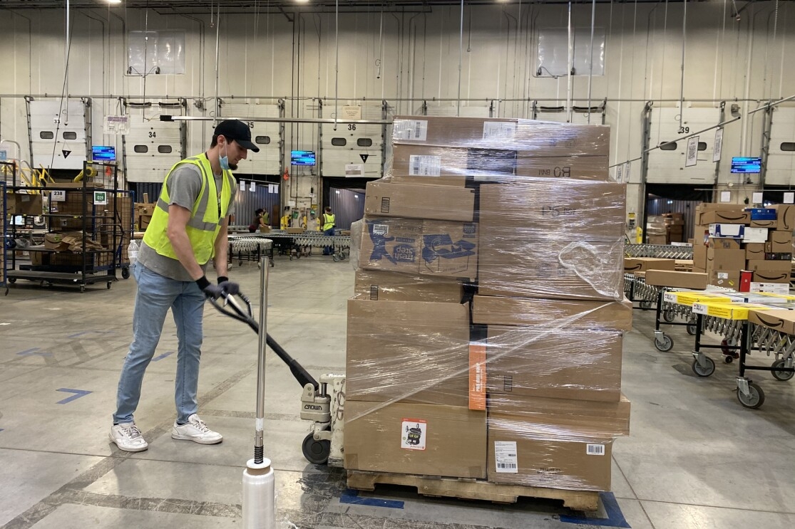 A man moves a pallet of goods.