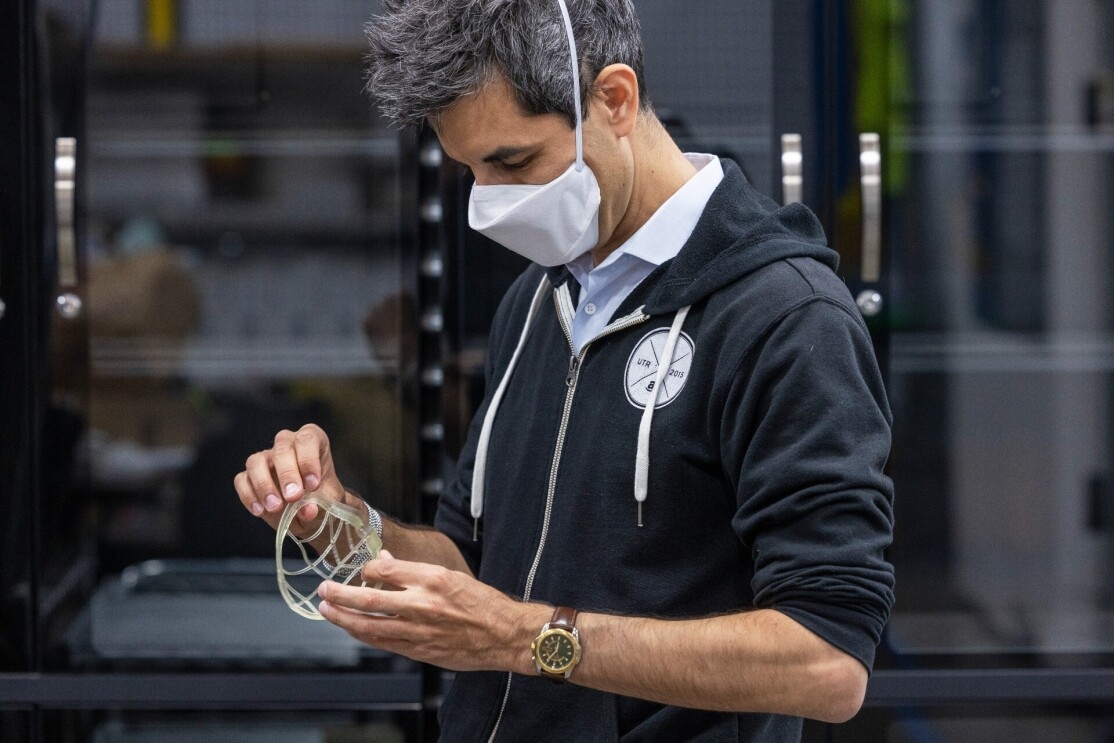 Siegel wears a face mask and inspects a mask prototype.