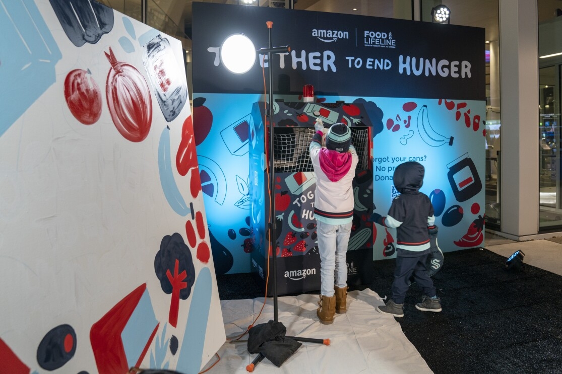 Kids donating canned goods outside of the Together to End Hunger food drive at Climate Pledge Arena. 