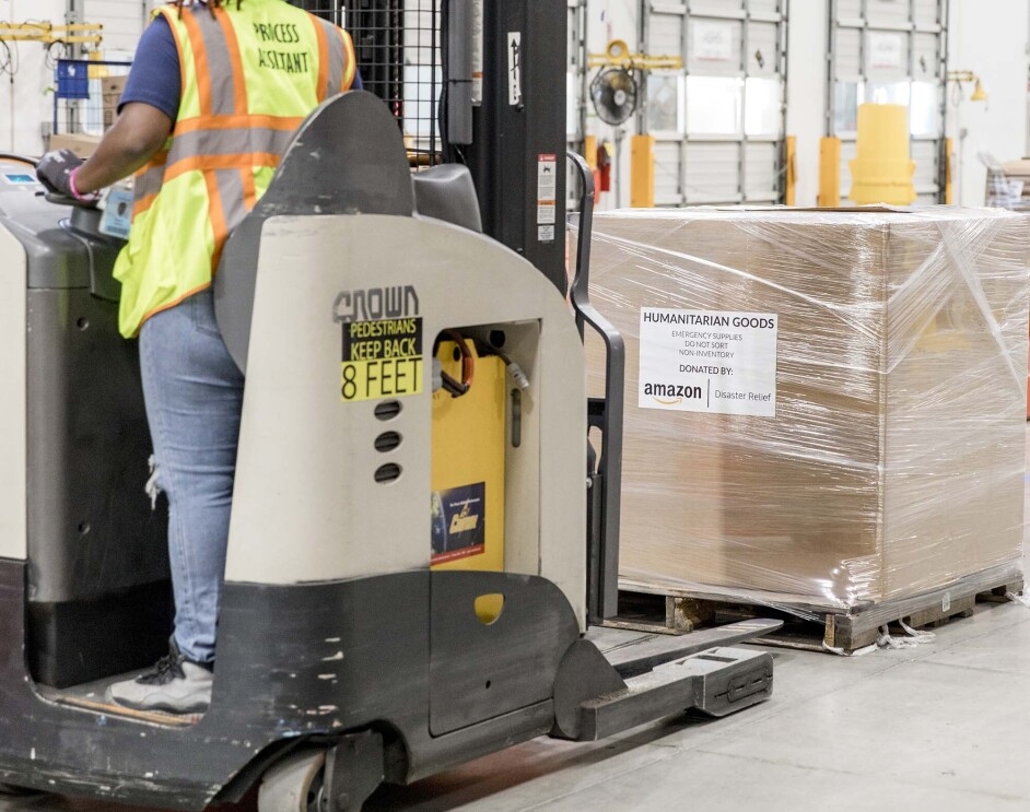 Person working with an Amazon Disaster Relief Hub prepares supplies for humanitarian and disaster relief efforts. 