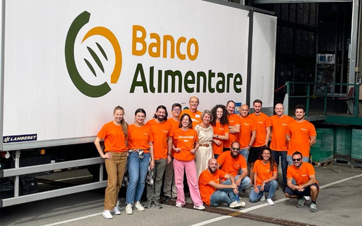 A group of Amazon volunteers wear orange T-shirts.