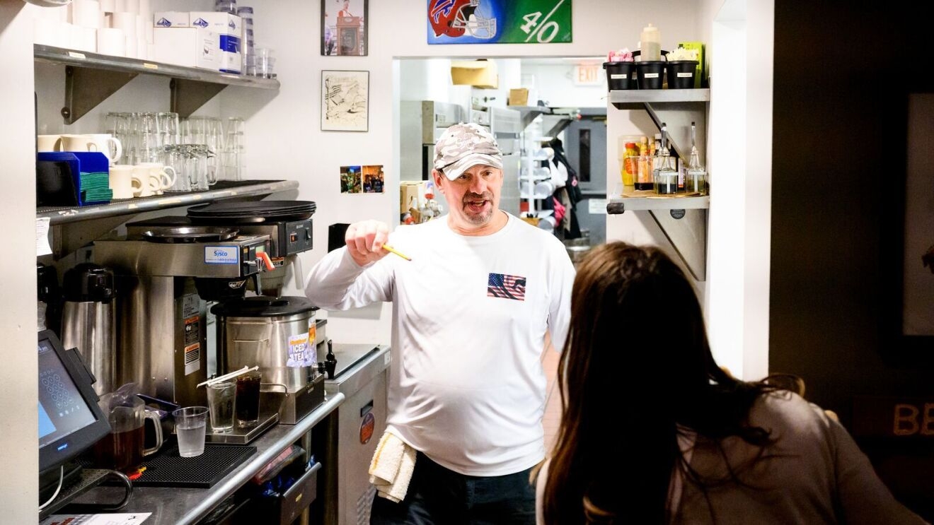 A photo of Jimmy Cirrito, owner of Jimmy’s Old Town Tavern in Herndon, Virginia, speaking with an employee in the tavern kitchen.