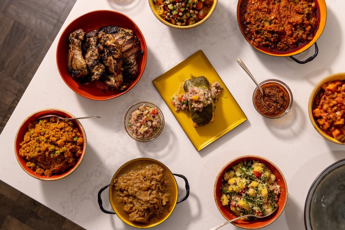 An image of multiple food dishes on red and yellow plates and bowls.