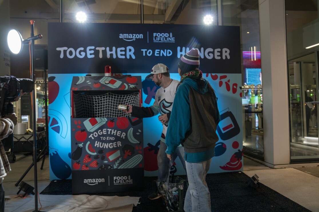 Two people donating to the Together to End Hunger food drive. 