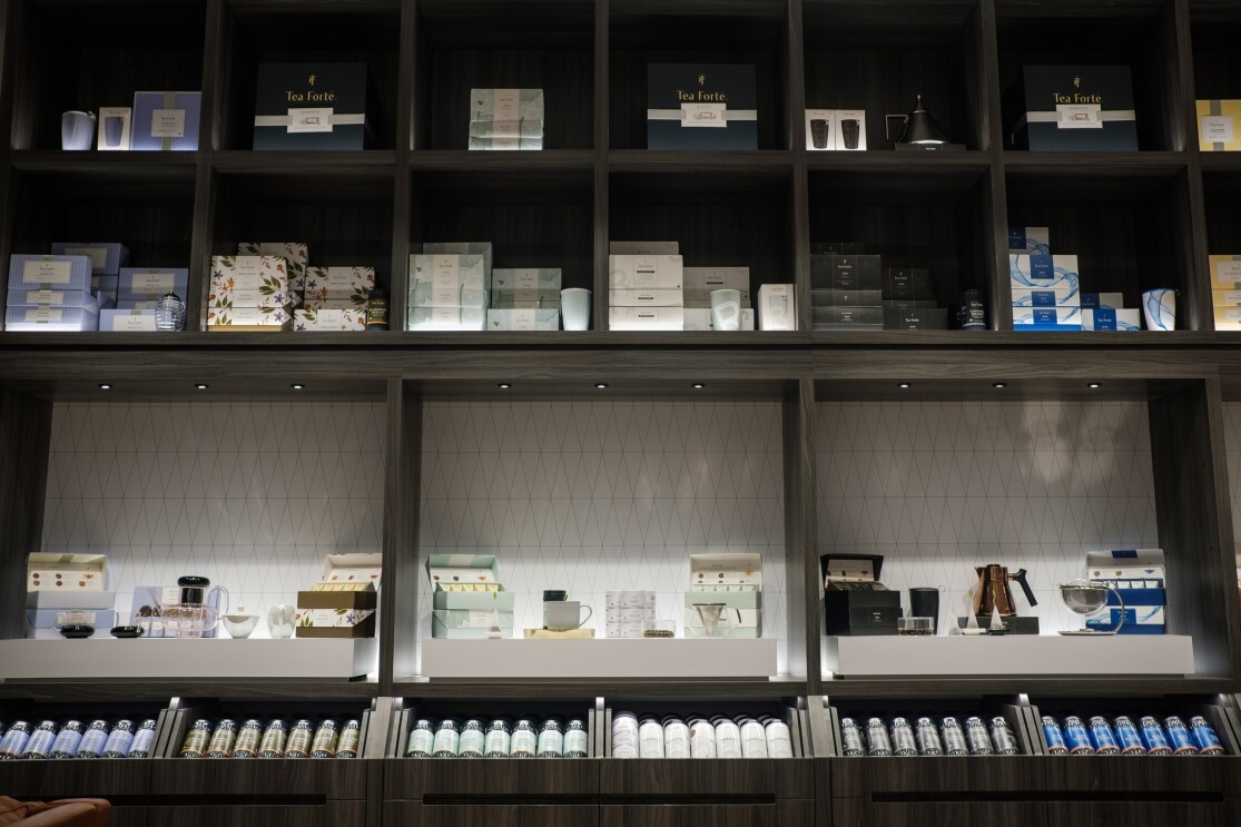 Shelves containing a variety of packaged products as well as teacups and teapots.