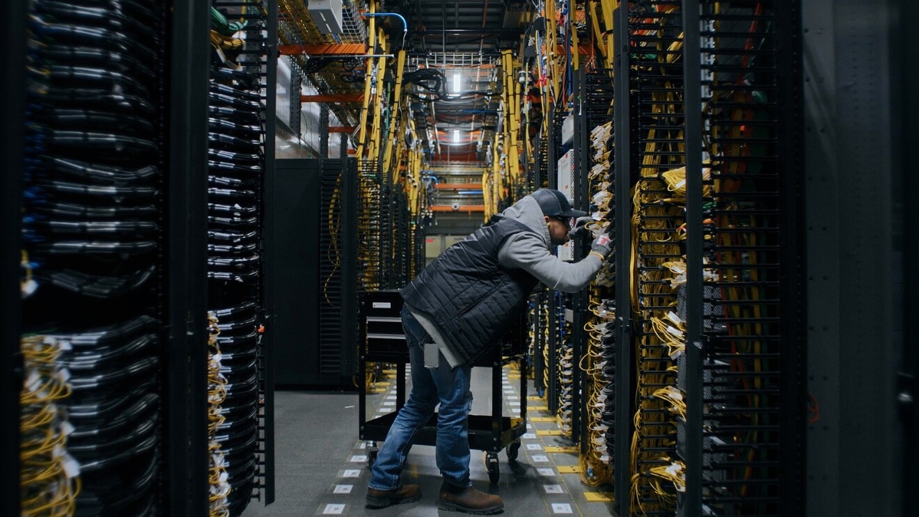 A photo of Fidel Contreras checking cables within an AWS Data center