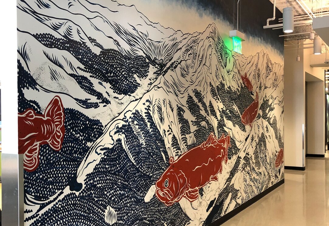 A painted mural of a mountain landscape and koi fish at Amazons denver office.