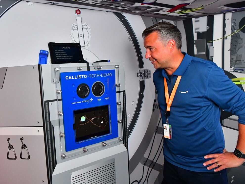 An image of a man staring at a screen during a demo of a mock space shuttle.