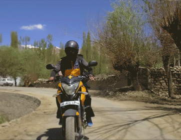 A motorcycle drives along  winding roads.