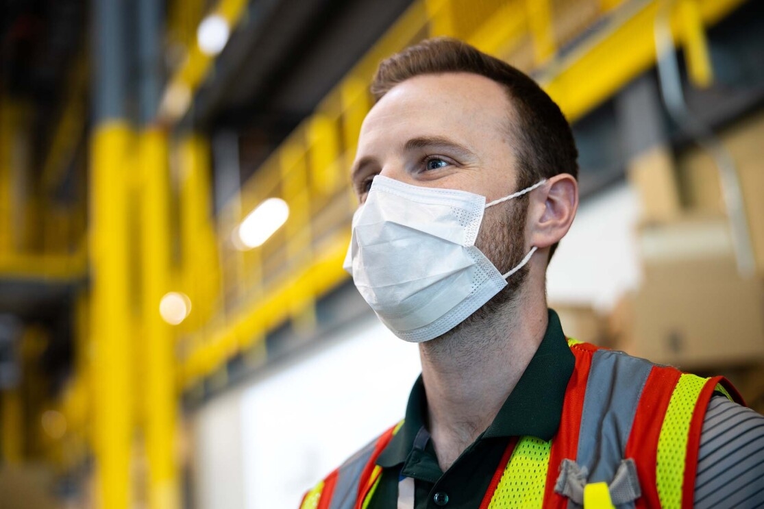 Amazon associate in a fulfillment center following additional safety proceedures in response to the COVID-19 pandemic