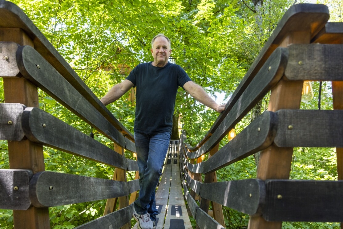 A man stands on an aerial footbridge.