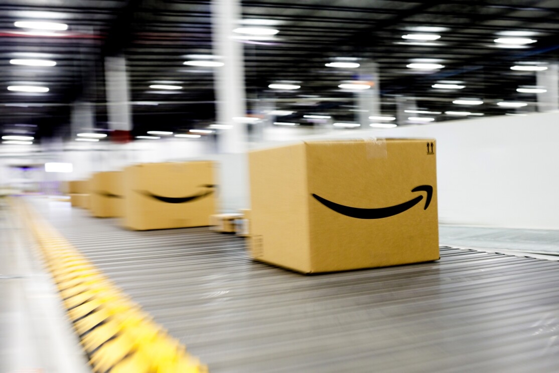 Amazon smile boxes move move along a conveyor belt within an Amazon Fulfilment Center or warehouse.