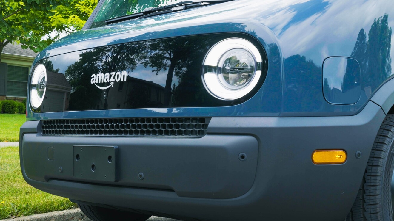 The front end of the Amazon Rivian delivery vehicle that features an Amazon logo in between two headlights.