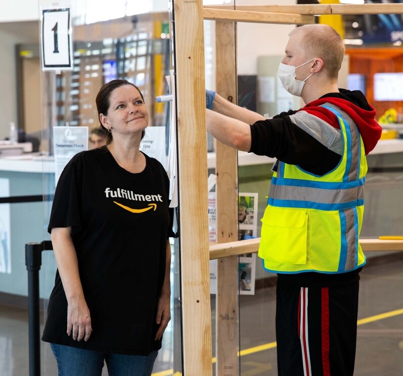 Amazon associate in a fulfillment center following additional safety proceedures in response to the COVID-19 pandemic