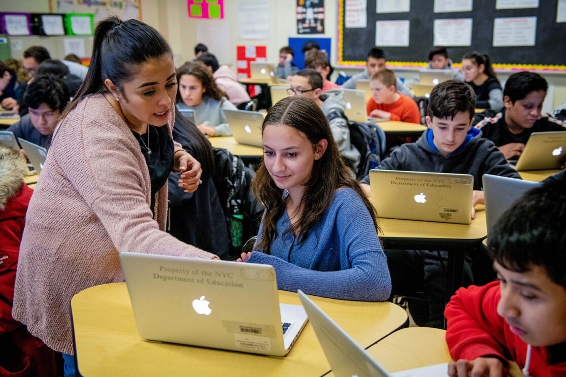 Students work on coding programs on laptop computers in a classroom at a New York City school. 