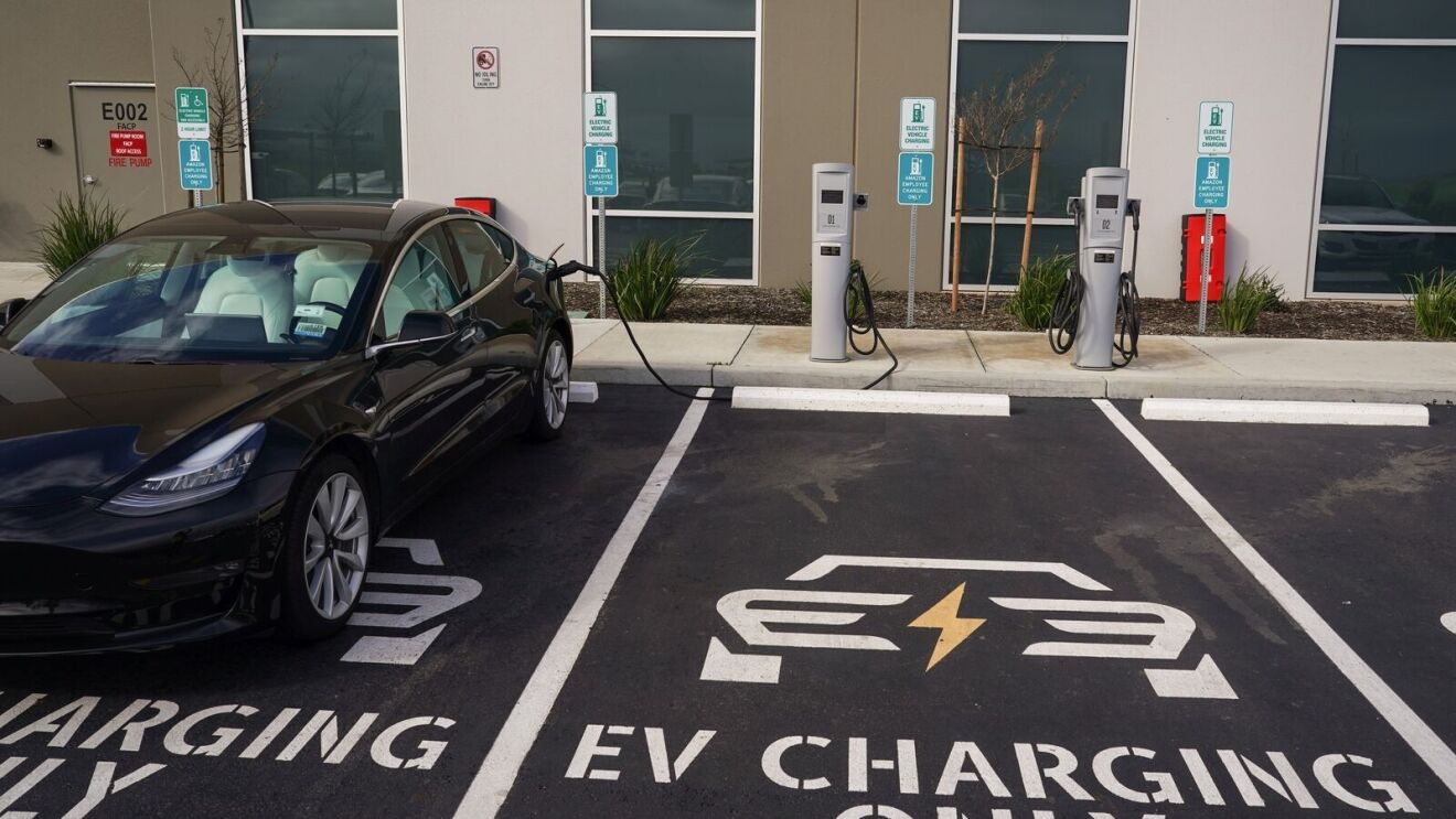 Electric vehicle charging station with Tesla plugged in