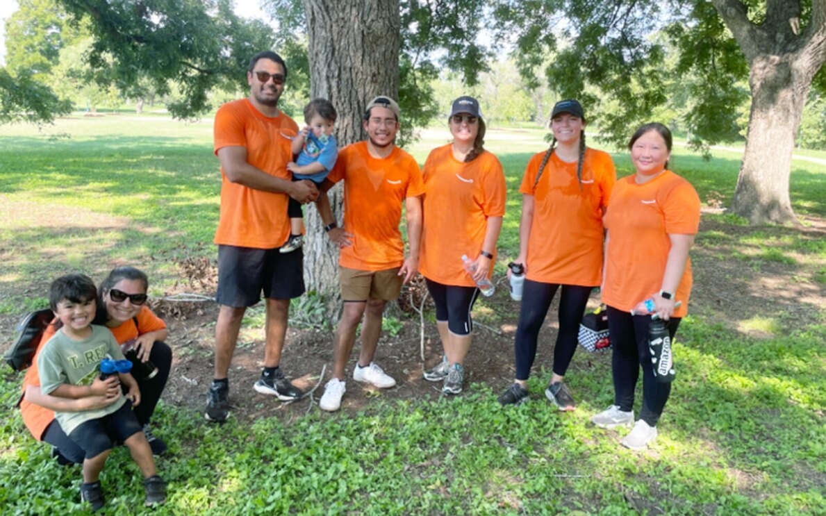 A group of Amazon volunteers wear orange T-shirts.