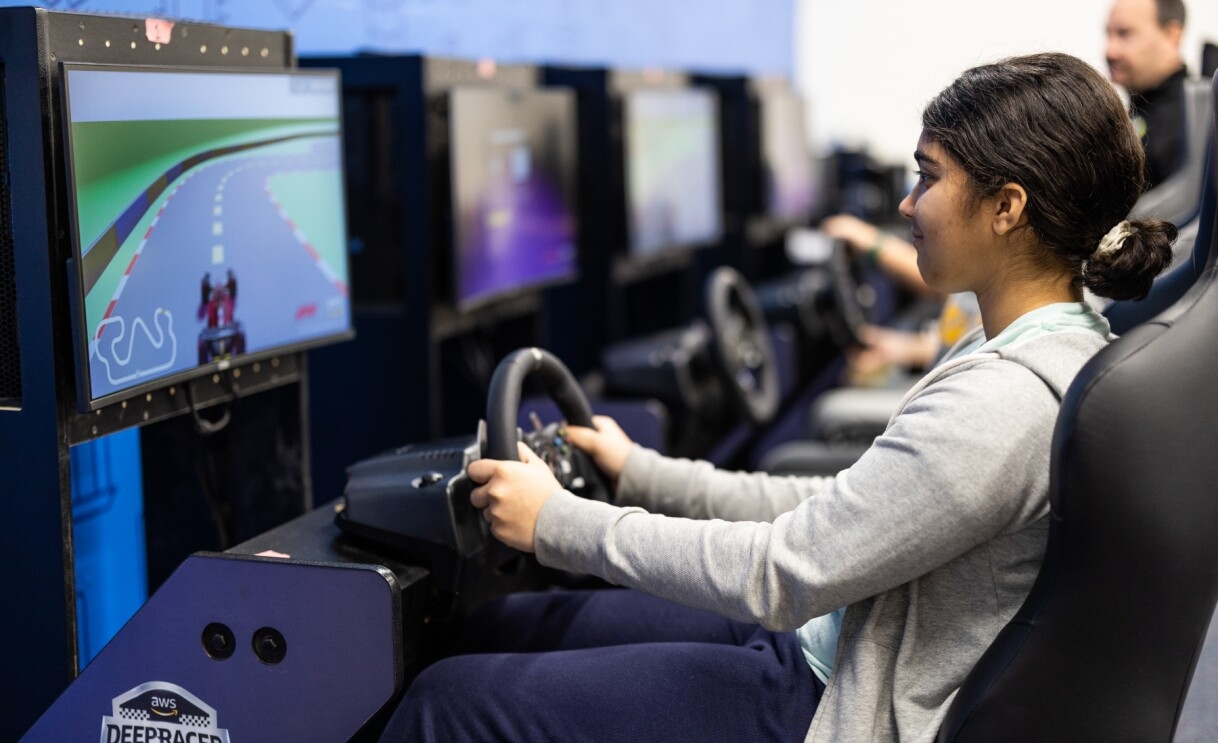 A photo of a student playing driving a car in a virtual game.