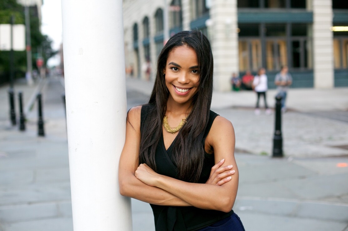 Woman smiles at the camera, in a headshot