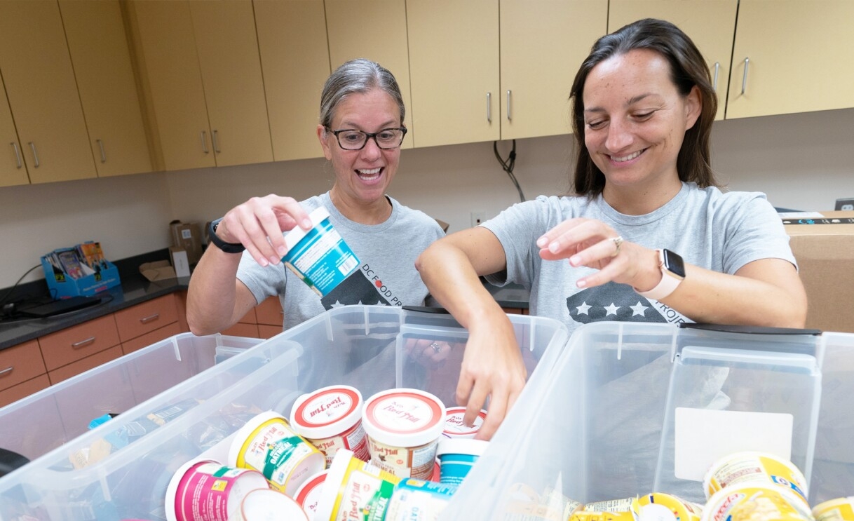 An image of two women assorting food items. 