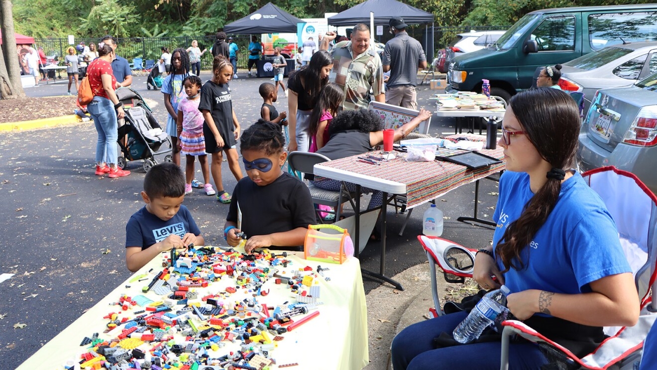 A photo of two children playing with LEGO blocks at a  table at an AWS Community event.