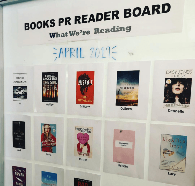 An image of the Books PR Reader Board, a whiteboard featuring her team's favorite books from the month. 