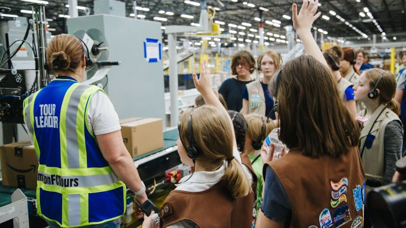 An image of Girl Scouts touring an Amazon fulfillment center.